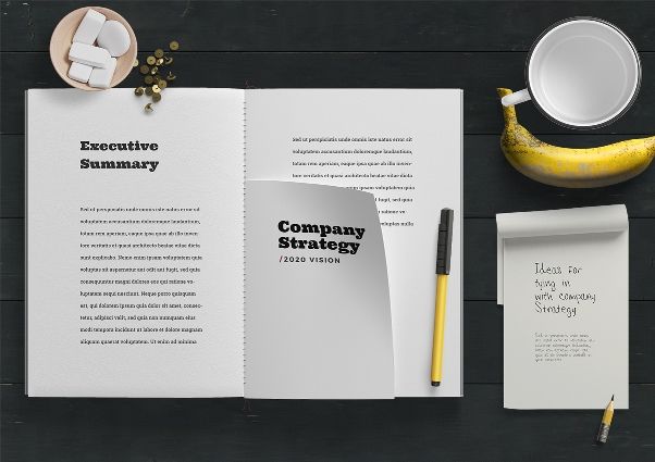 Image of an open notepad with 'Company Strategy' text; also cup and banana in picture