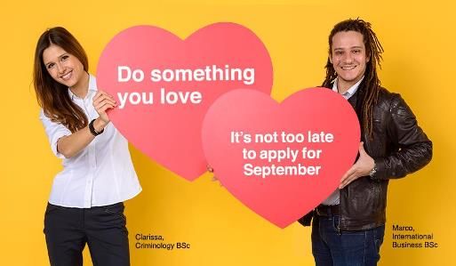 Image of a man and woman holding two love heart shaped signs: 